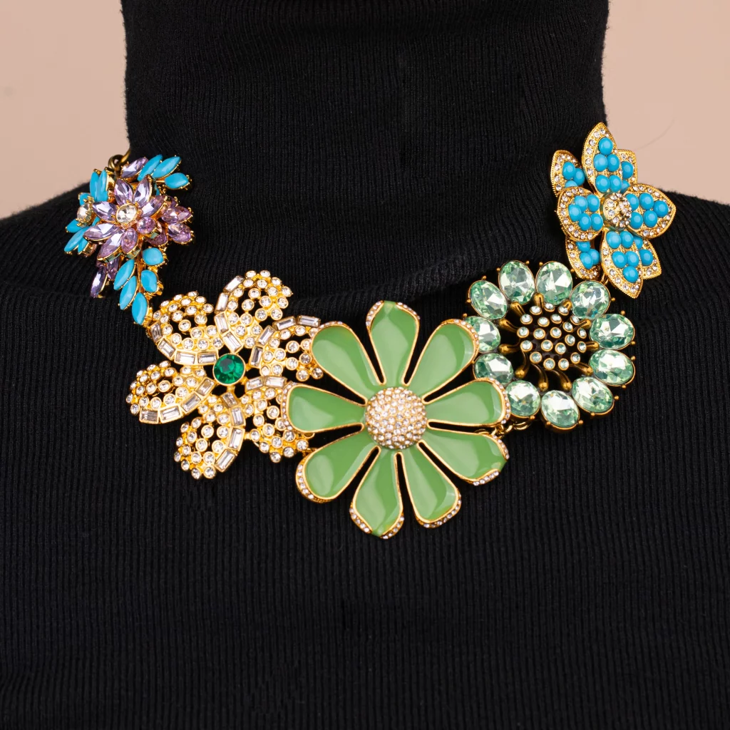 Female model wearing a metal flower necklace, a black turtleneck