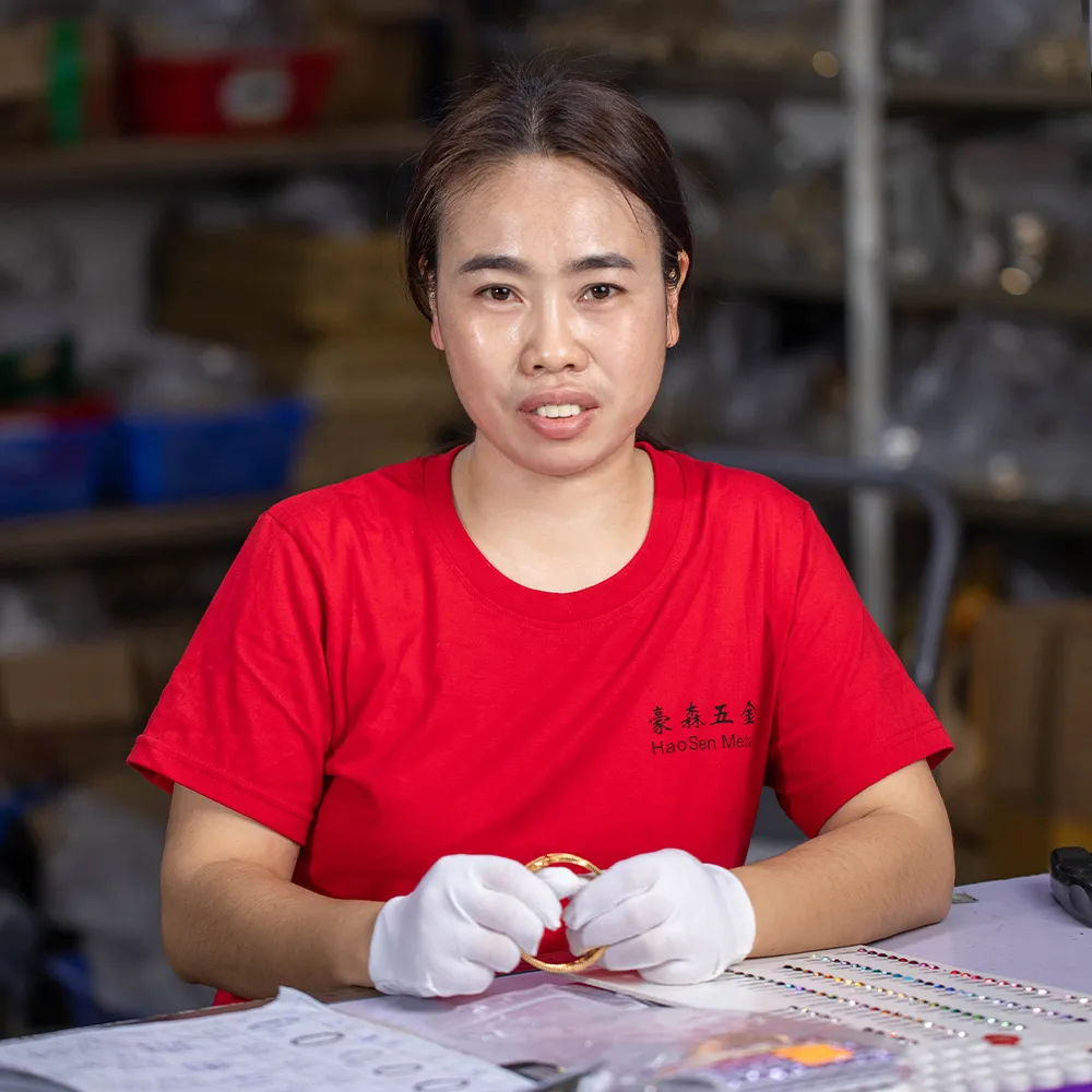 Aijiang Yang-QC Lead inspecting jewelry for quality and compliance at Haosen Jewelry